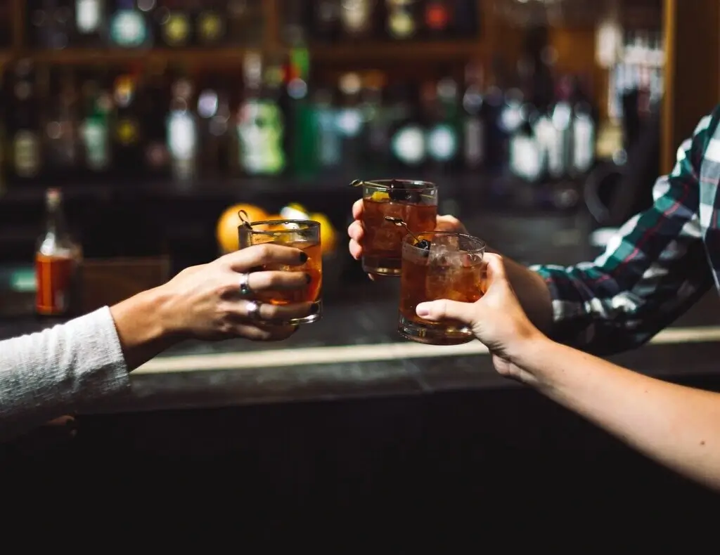 Friends sharing a toast with their drinks, in a bar on a nice night out